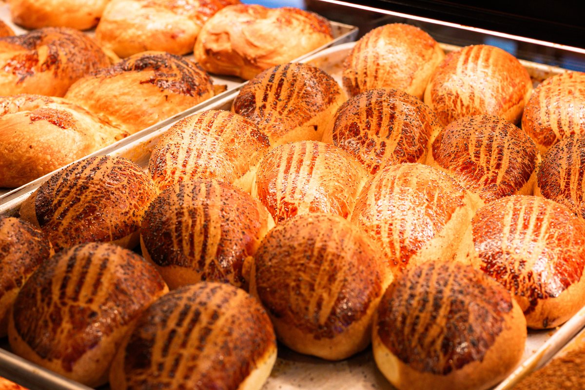 Assorted freshly baked breads and buns on a wooden board