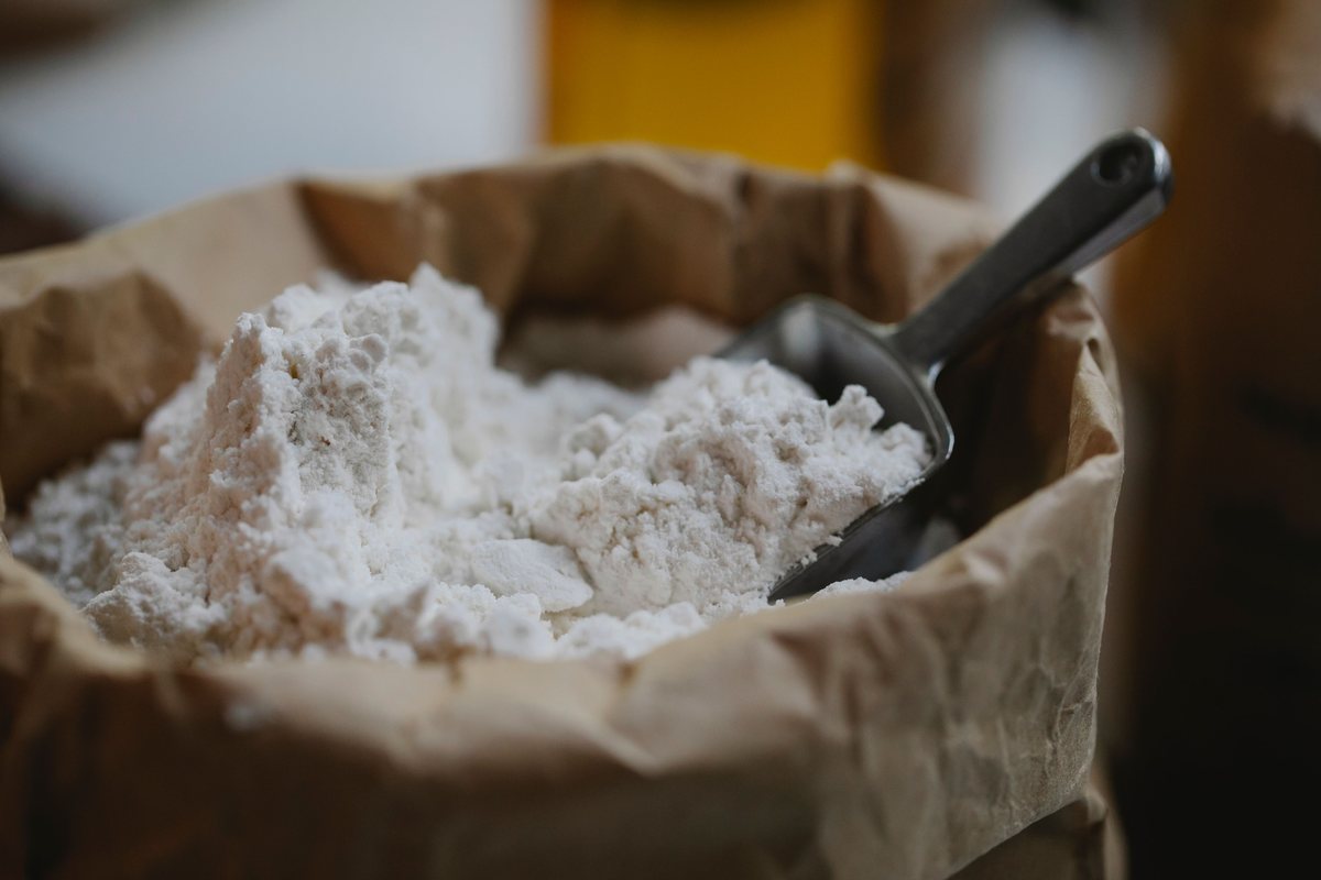 Wheat flour being sifted into a stainless bowl