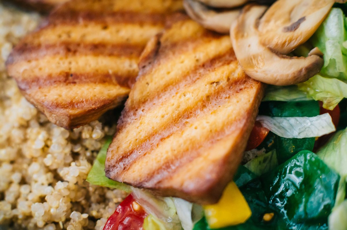 Plant-based meat alternative patties on a wooden board